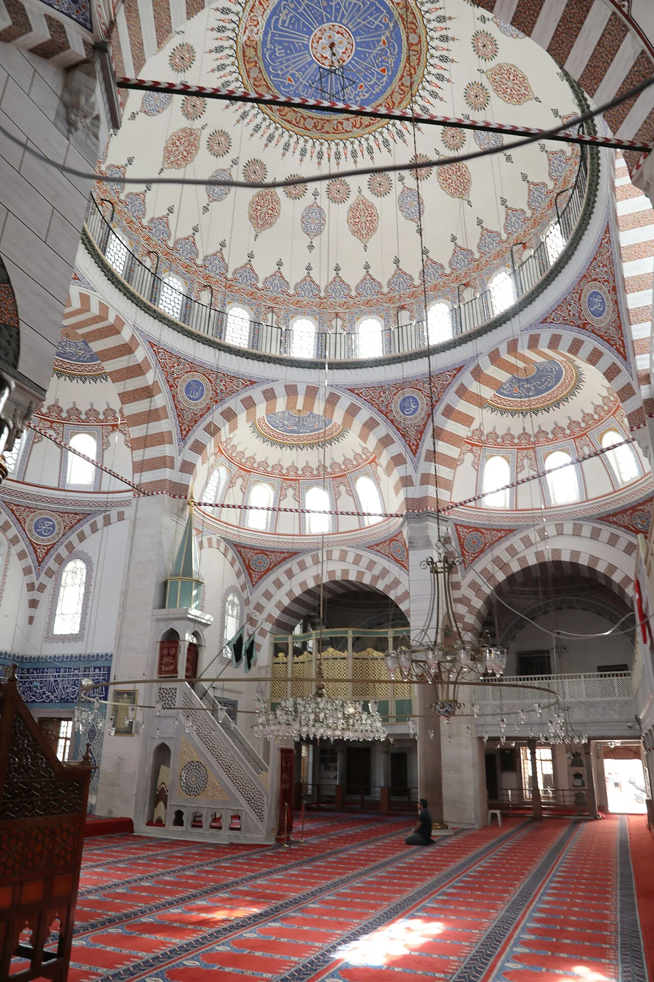 قاعة الصلاة في جامع الوالدة العتيق بمنبرها وسجادها الأحمر وقبتها المزخرفة، أيلول 2022