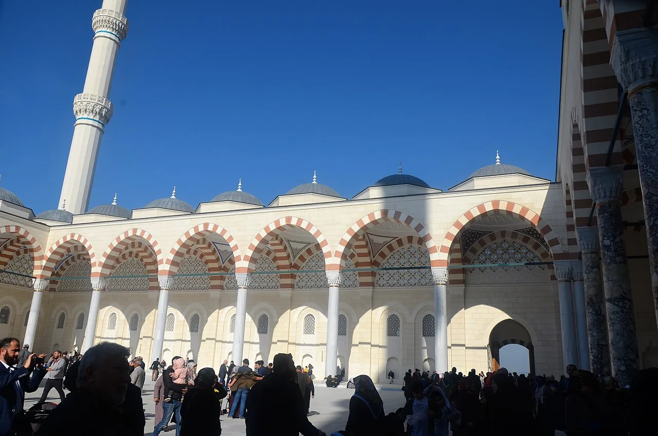 فناء جامع جاملجة الكبير وأروقته ذات العقود الملوّنة، والزوار يملؤونه، آذار 2019
