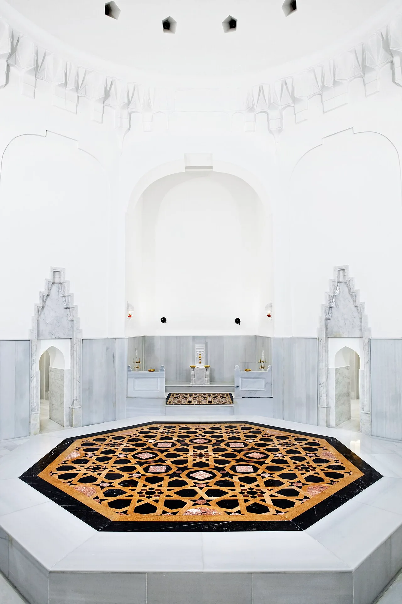 حجر الحرارة الثماني المطعّم بالرخام الملوّن تحت القبة البيضاء داخل الحمام بعد ترميمه، آذار 2011