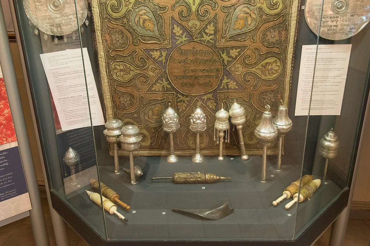 خزانة عرض فيها تيجان فضية للفائف التوراة وقطع طقسية أمام ستارة مطرّزة، حزيران 2014